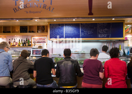 Espagne Barcelone clients assis sur des tabourets de bar à tapas restaurant à produire de la Boqueria market Banque D'Images