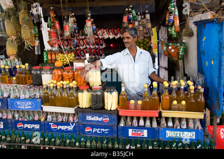 Un homme travaille dans un stand de rafraîchissements de Kochi dans le Kerala, en Inde. Il vend des boissons y compris des boissons au citron. Banque D'Images