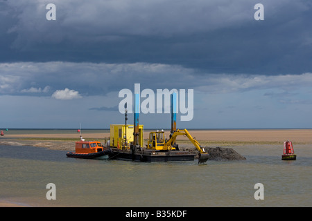 Wells-next-the-Sea un port sur la côte nord du comté de Norfolk en Angleterre.Automne drague au travail Banque D'Images