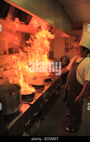 Cuisine Chef Thaï mâle avec flaming wok dans un restaurant Cuisine, Cuisine orientale Banque D'Images