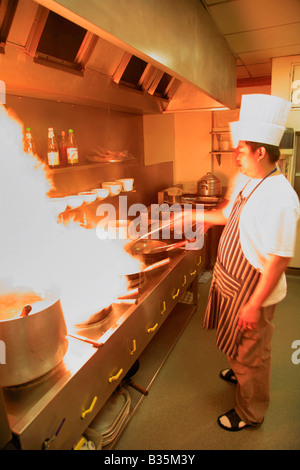 Cuisine Chef Thaï mâle avec flaming wok dans un restaurant Cuisine, Cuisine orientale Banque D'Images