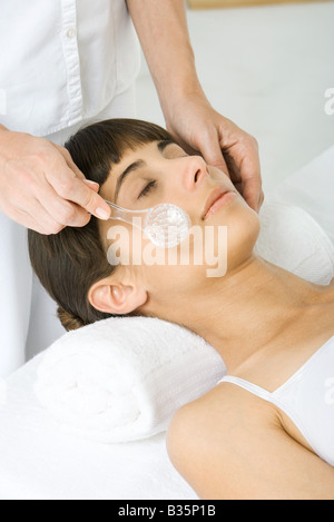 Femme qui a son visage exfoliée, portrait de femme à l'aide de la brosse faciale Banque D'Images