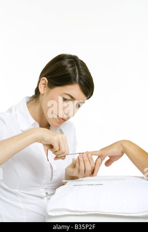 Découpage d'un coiffeur les ongles de femme avec des ciseaux, cropped view of hand Banque D'Images