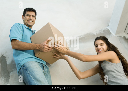 Père et fille déménagement boîte carton ensemble, low angle view Banque D'Images