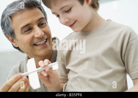 Mature man and boy holding toy plane ensemble Banque D'Images