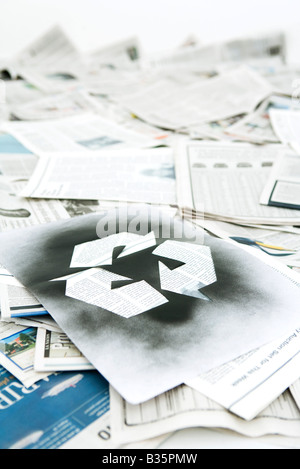 Symbole de recyclage inscrit sur pile de journaux Banque D'Images