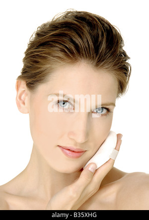 Portrait d'une jeune femme à l'aide de poudre à pâte Banque D'Images
