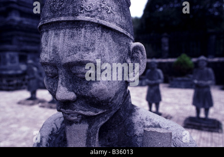 Close up detail d'une statue en pierre de Mandarin face avec statues en pierre derrière au mausolée de Khai Dinh Hue Vietnam Banque D'Images