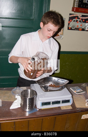 Jeune homme pesant des sucreries traditionnelles dans la région de sweet shop Banque D'Images