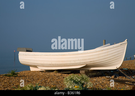 Un bateau de pêche reposant sur une plage de galets à Dungeness, Kent, UK Banque D'Images