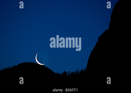 Un croissant de lune se lève avant l'aube directement sur le haut de Sentinel Dome Yosemite National Park California USA Banque D'Images