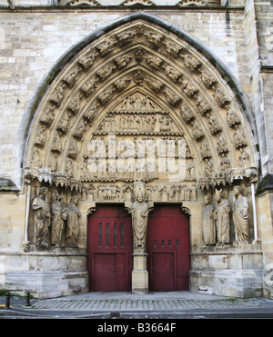 Reims, France. Reliefs, statues et portes marron/rouge à la célèbre cathédrale de Notre-Dame de Reims. Banque D'Images