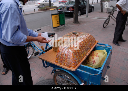 Minorité musulmane chinois vend des collations musulmane traditionnelle de sa bicyclette panier Banque D'Images