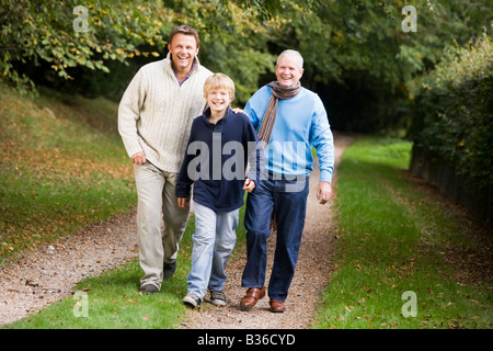 Deux hommes et jeunes boy walking on path outdoors smiling (selective focus) Banque D'Images