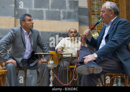 Les hommes fumeurs narguilé dans un café dans la vieille ville de Damas en Syrie Banque D'Images