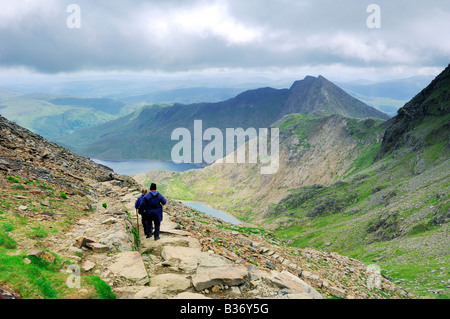 Deux personnes marchant sur la piste vers Pyg Llyn Llyn Llydaw Glaslyn et sur le haut des pentes escarpées du Mont Snowdon Banque D'Images