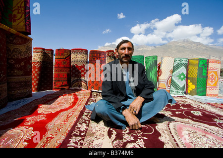 Tapis afghan à l'homme de vendre le Tadjikistan Afghanistan Ishkashim marché près de la frontière du Tadjikistan Banque D'Images