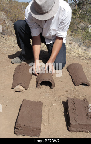 Apprendre à faire le toit de tuiles demi-rondes avec soin un jeune garçon organise un carreau humide où il sèche au soleil Chirche, Guia de Isora, Tenerife Banque D'Images