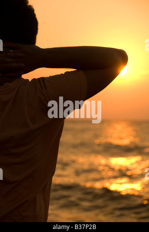 Un homme qui regarde le lever du soleil Banque D'Images