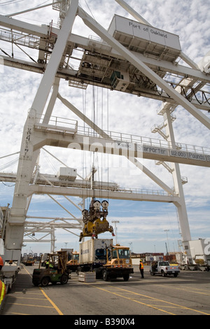 Oakland California une grue se charge des conteneurs d'expédition sur un porte-conteneurs dans le port d'Oakland Banque D'Images