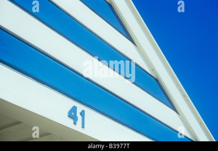 Détail de cabane de plage peint en bandes alternées de lumière bleue et blanche sous un ciel avec numéro 41 Banque D'Images