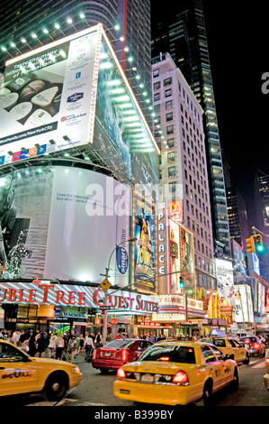 NEW YORK CITY, New York, États-Unis — Une scène nocturne animée de Times Square, l'intersection emblématique de Midtown Manhattan, déborde d'activité. Les taxis jaunes naviguent à travers les rues bondées, leur couleur distinctive se démarquant sur la toile de fond des panneaux lumineux au néon, des panneaux d'affichage massifs, et des écrans LED. Des foules de piétons, touristes et habitants, remplissent les trottoirs et les passages, incarnant l'énergie de «la ville qui ne dort jamais». Banque D'Images