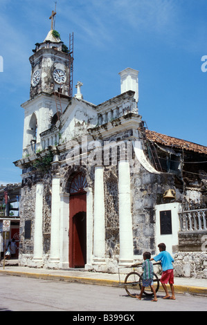 Les garçons poussant un panier à côté de l'église dans la ville de San Blas, Nayarit, Mexique Banque D'Images