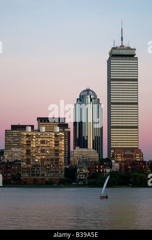 Un voilier naviguant en face de l'horizon de Boston et le contrôle prudentiel des capacités au coucher du soleil. Banque D'Images