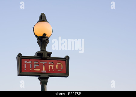 Un éclairage magnifique signe métro Parisien dans le style art nouveau tourné au crépuscule contre un ciel bleu clair et brillant de l'intérieur. Banque D'Images