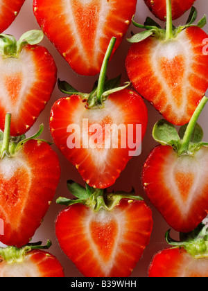 Coupe de fraises biologiques en forme de cœur stylisé , concept créatif photo représentant un cœur en bonne santé, sur un fond blanc. Banque D'Images