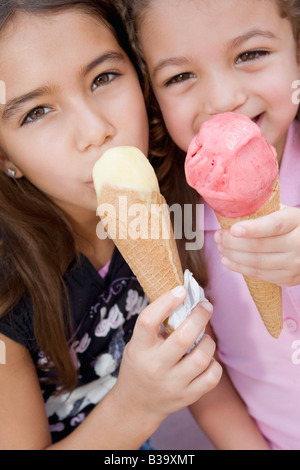 Hispanic sisters eating ice cream cones Banque D'Images