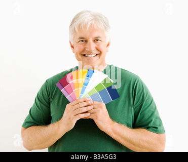 Middle aged man holding up paint swatches Banque D'Images