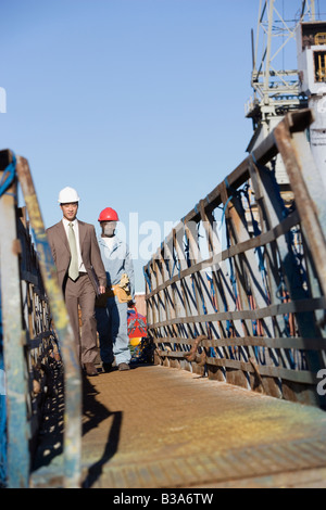 Homme d'affaires multi-ethniques et construction worker walking Banque D'Images