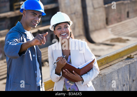 African American businesswoman et construction worker pointing Banque D'Images