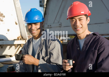 Multi-ethnic male construction workers drinking coffee Banque D'Images