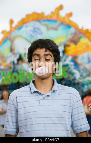 Mixed Race adolescent blowing bubble gum bubble Banque D'Images