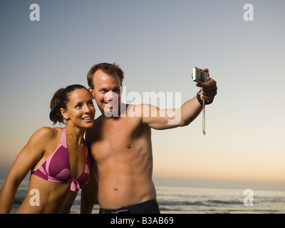 Multi-ethnic couple taking own photograph Banque D'Images