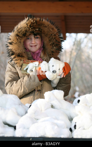 Jeune fille choisir un cadeau à partir de la pile de Knut l'ours polaire jouets la boutique de souvenirs au zoo de Berlin, Allemagne Banque D'Images