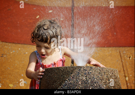 Enfant pulvérisés par une fontaine à l'aire urbaine à Brooklyn New York Banque D'Images