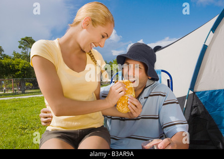 Hispanic Woman feeding sandwich pour petit ami Banque D'Images
