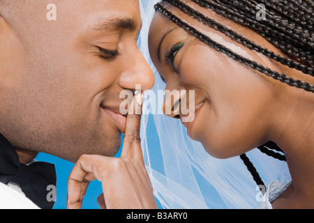 Mariée africaine de toucher les lèvres du marié Banque D'Images