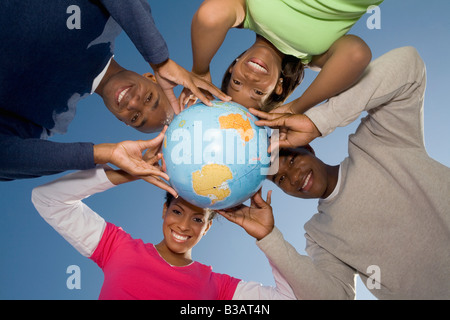 Multi-ethnic hands holding globe Banque D'Images