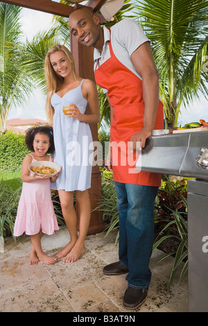 Mixed Race family barbecuing Banque D'Images