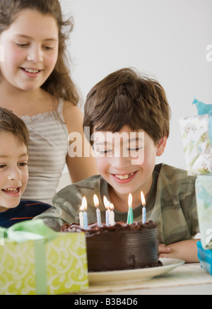 Hispanic boy looking at birthday cake Banque D'Images