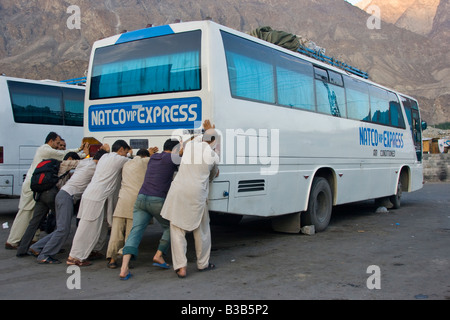 Les passagers pakistanais pousser le démarrage du bus longue distance entre le Pakistan et la Chine Kashgar Gilgit Banque D'Images