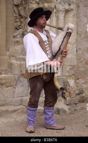 Musicien médiéval reconstitution jouant la cornemuse en peau de instrument de musique La musique de harpe English costume Banque D'Images