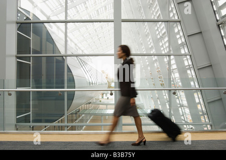 Hispanic businesswoman pulling suitcase Banque D'Images