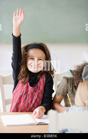 Girl raising hand in class Banque D'Images