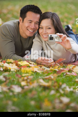 Asian couple taking own photograph Banque D'Images