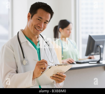 Asian male doctor holding chart Banque D'Images